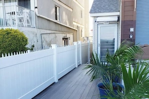 A residential building with a white picket fence, a door labeled '405', and potted plants on the porch. - Modern Beachfront Suite 206 (Ocean City)
