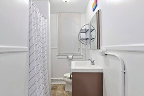 A bathroom with a shower, toilet, and sink. - Modern Beachfront Suite 206 (Ocean City)