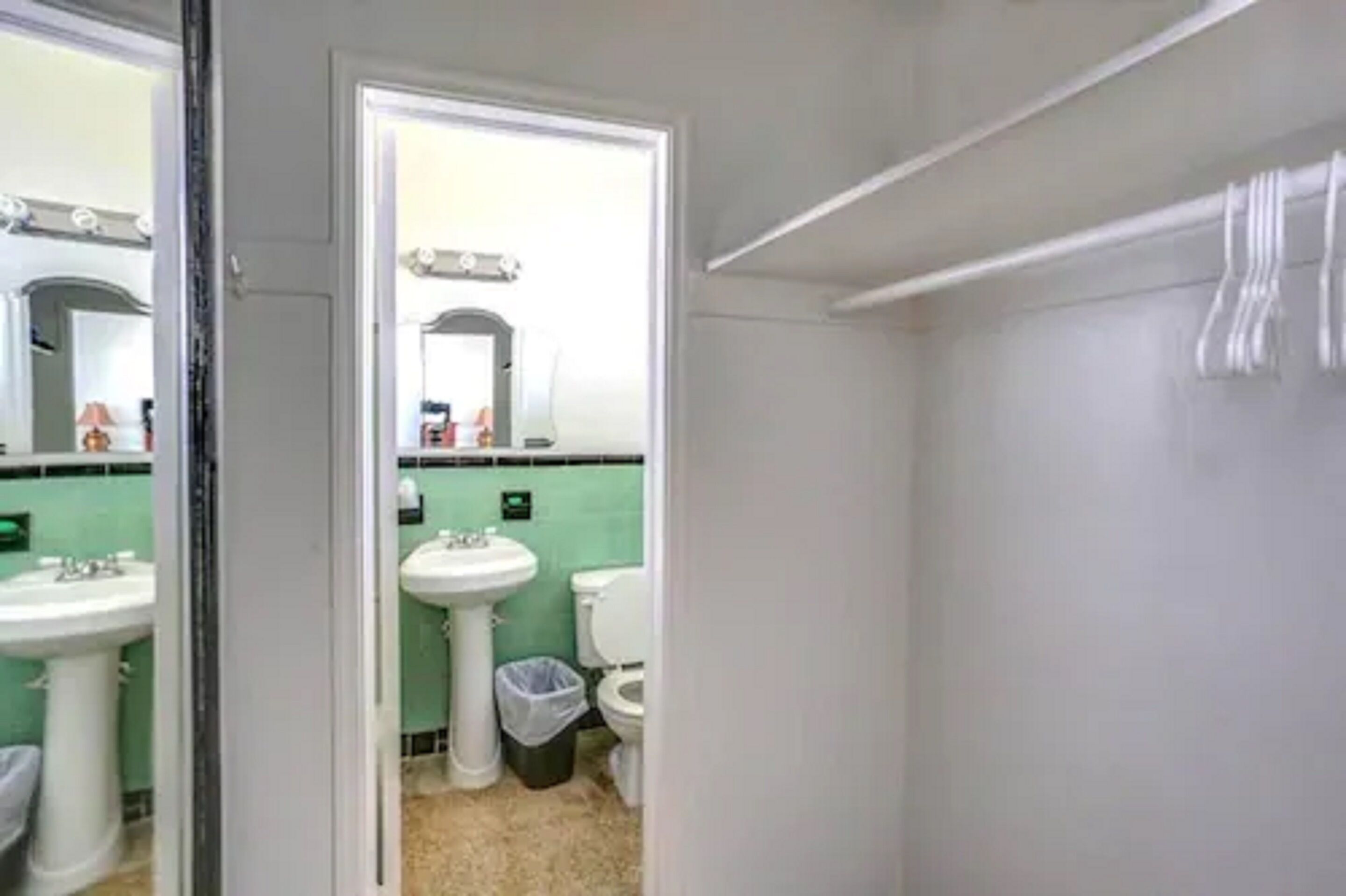 Un baño con lavamanos, inodoro y espejo.