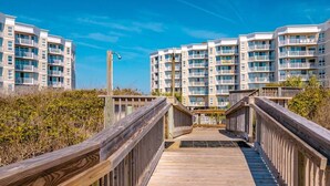 A wooden boardwalk leading to a beachfront residential building with multiple balconies. - Ocean view, 2BR, 2BA Condo, St. Regis #3213, Topsail, NC (North Topsail Beach)
