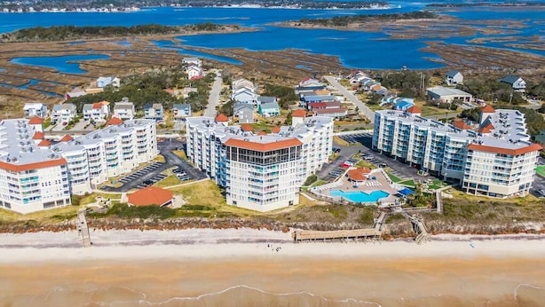 A coastal residential area with multiple high-rise buildings, a beach, and a marina. - Ocean view, 2BR, 2BA Condo, St. Regis #3213, Topsail, NC (North Topsail Beach)