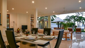 A dining area with a table set for four, chairs, a television, and a view of the outdoors.