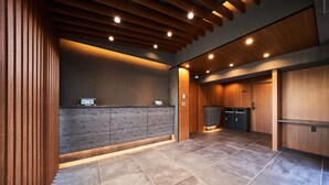 A modern reception area with a wooden reception desk, a computer, and a wooden door labeled "office". - Grand STAY Hakata Station North (Fukuoka)