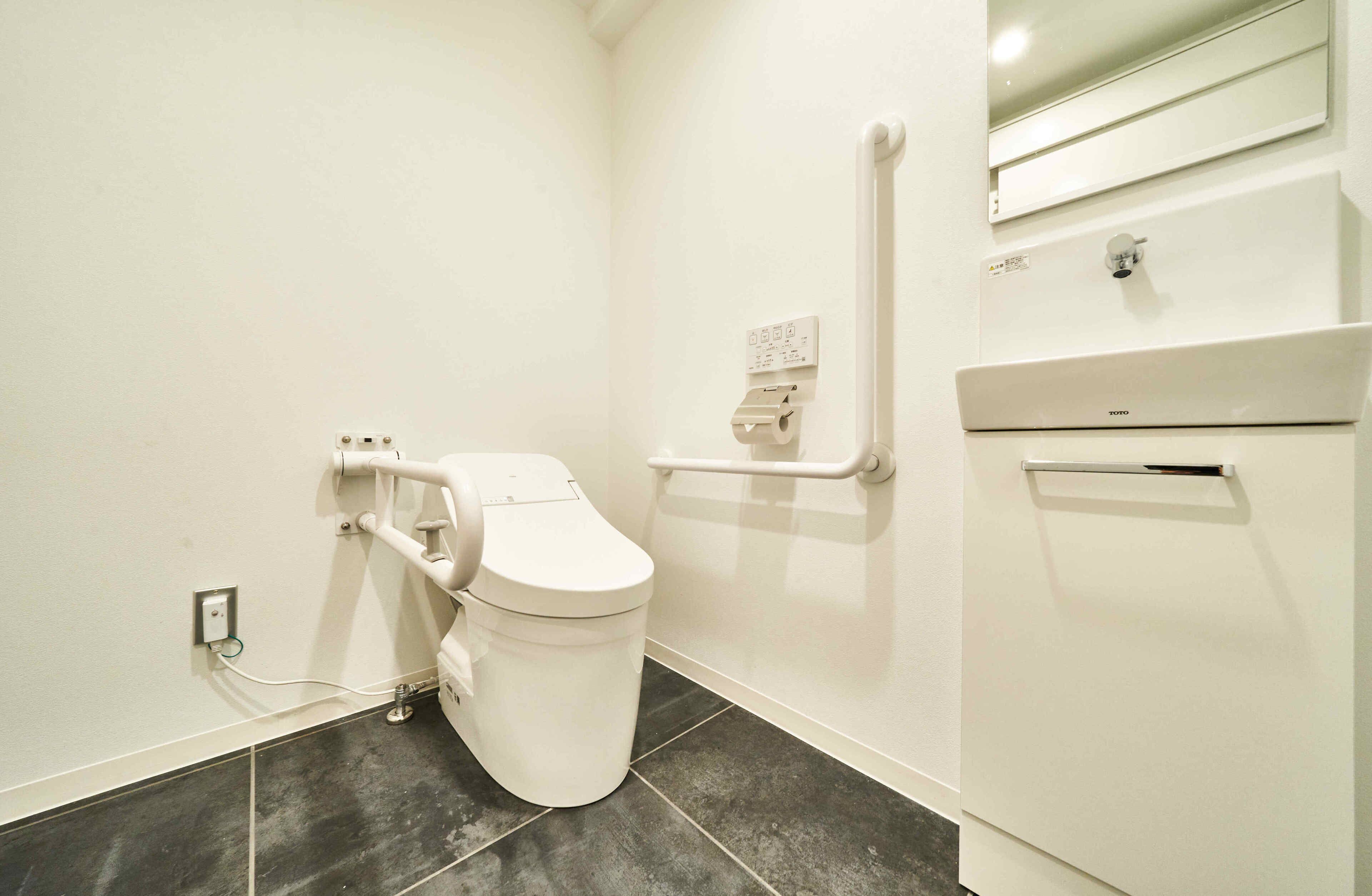 A small, modern bathroom with a white toilet, a white sink, and a mirror above the sink.