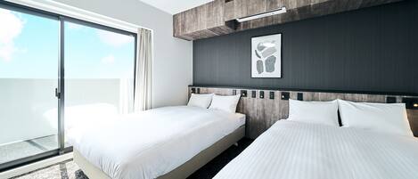 Habitación de hotel moderna con dos camas, un gran ventanal corredero y vistas al cielo.