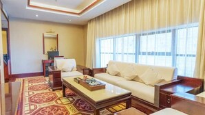 A spacious living room with a large sofa, a coffee table, and a patterned rug. - Yijian Haoting Holiday Hotel (Zhuhai)