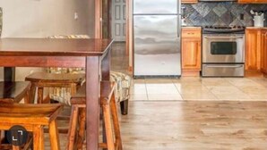 A kitchen with wooden cabinets, a stainless steel refrigerator, a microwave, and a stove. - Chelan Cabana Chalet (chelan)