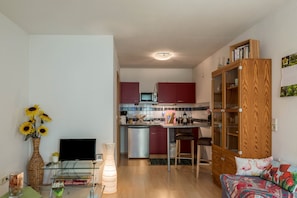 Una cocina moderna con microondas, refrigerador y armarios de madera.