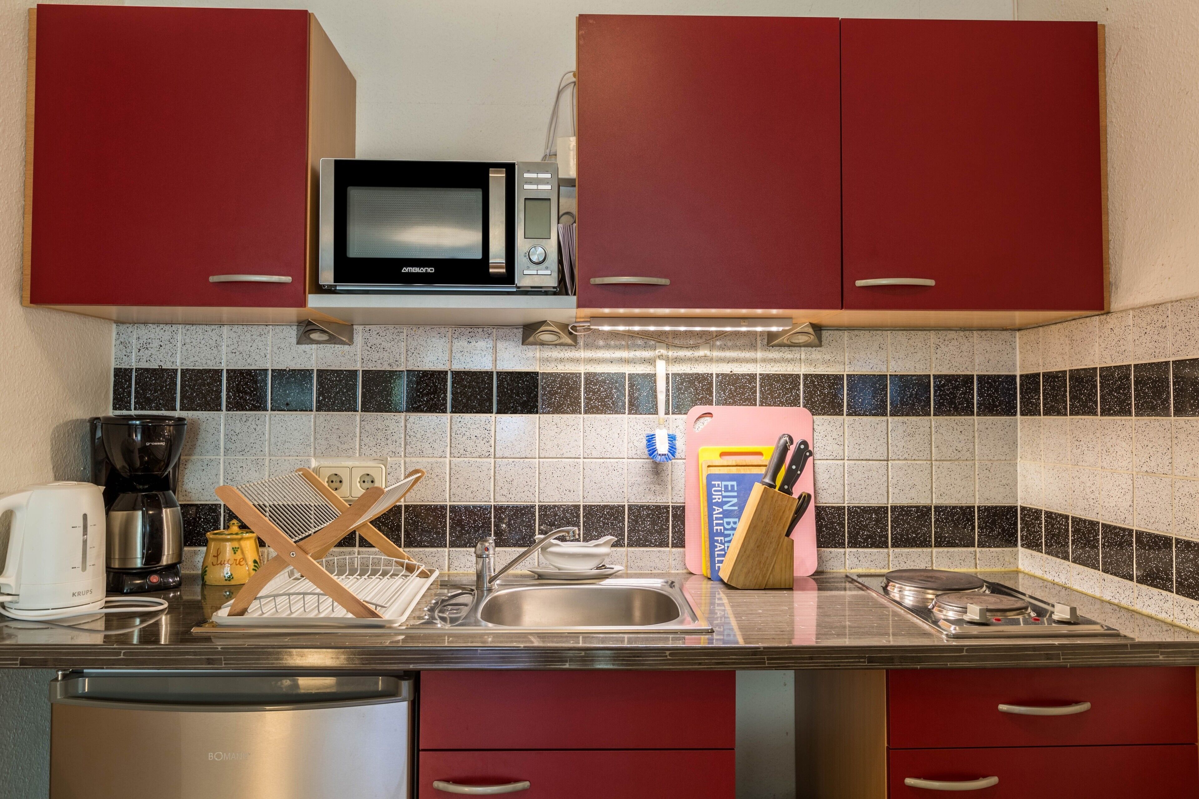 Una cocina equipada con microondas, pileta y diversos electrodomésticos.