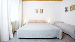 A bedroom with a large bed, two bedside tables, and a wooden ceiling. - Charming Apartment "Bregenz 6 Top 2" with Wi-Fi, Balcony, Terrace & Garden (Bregenz)