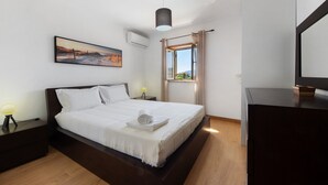 A bedroom with a bed, bedside tables, a lamp, a painting, a window, and a mirror. - Holiday Home Casa do Valado with Mountain View, Pool, Wi-Fi & Garden; Parking Available (Resende)