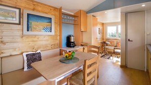 A wooden interior with a dining table, chairs, a bench, and a coffee machine. - Cabana Garden House with Shared Pool, Panoramic View & Wi-Fi (Loulé)