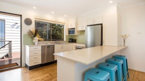 Una cucina moderna con isola centrale, elettrodomestici in acciaio inossidabile e mobili chiari.