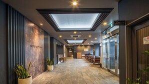 A modern hotel lobby with a skylight, potted plants, and a reception desk. - Route Inn Noda - Kokudou16gouzoi - (Noda)