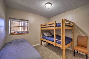 A bunk bed room with a window labeled "CAMPGROUND" and a chair. - Walk to New River Access! Family Cabin w/ Deck (Piney Creek)