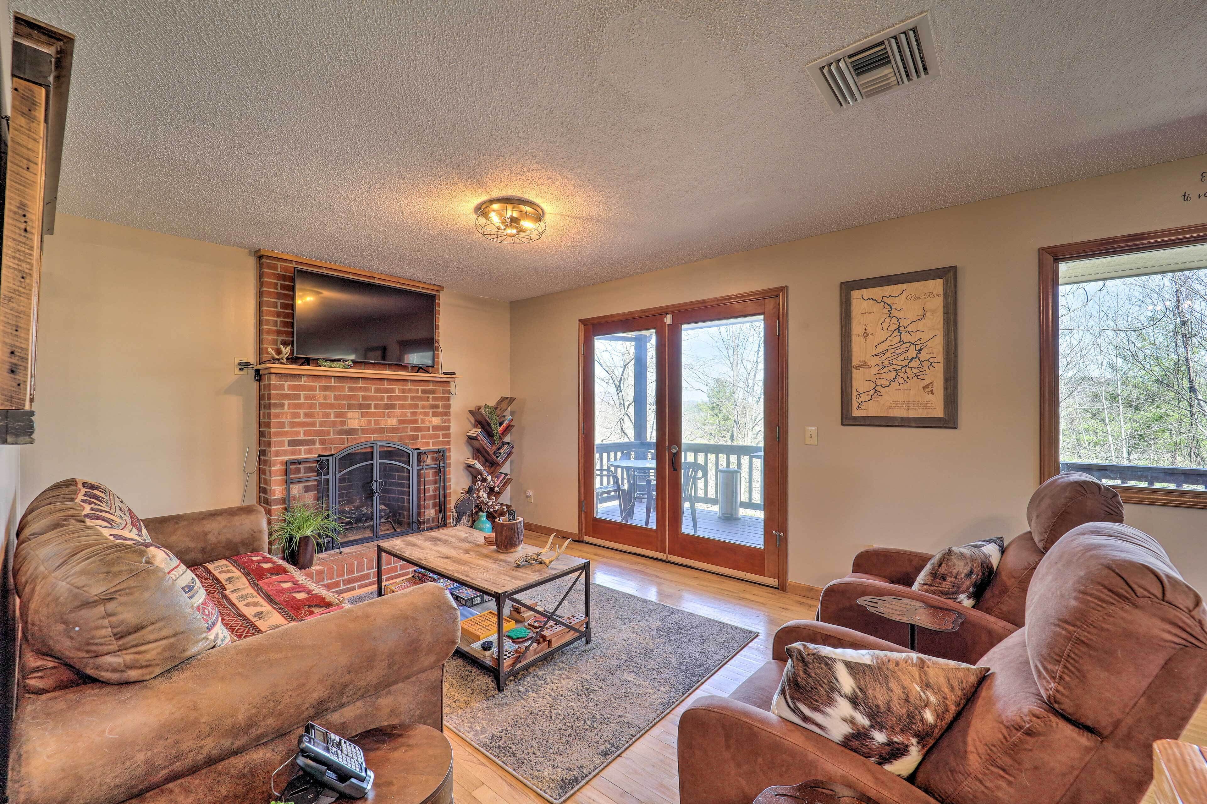 A living room with a fireplace, a television, and a large window.