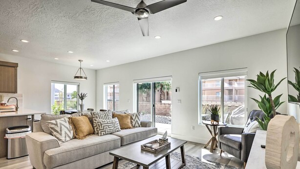 A modern living room with a sofa, coffee table, and a ceiling fan. - Spacious St. George Townhome w/ Grill & Views! (St. George)