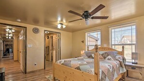 A bedroom with a wooden bed, a ceiling fan, and a nightstand with a lamp. - Cozy Home w/ Canyon Views: 2 Mi to Grand Staircase (Henrieville)
