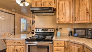 A kitchen with wooden cabinets, a stainless steel stove, a microwave, and a ceiling fan. - Cozy Home w/ Canyon Views: 2 Mi to Grand Staircase (Henrieville)