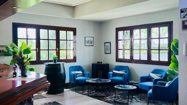 A lobby with a marble floor, blue armchairs, a reception desk, and large windows. - Hotel ITC Ciudad de Haro (Haro)