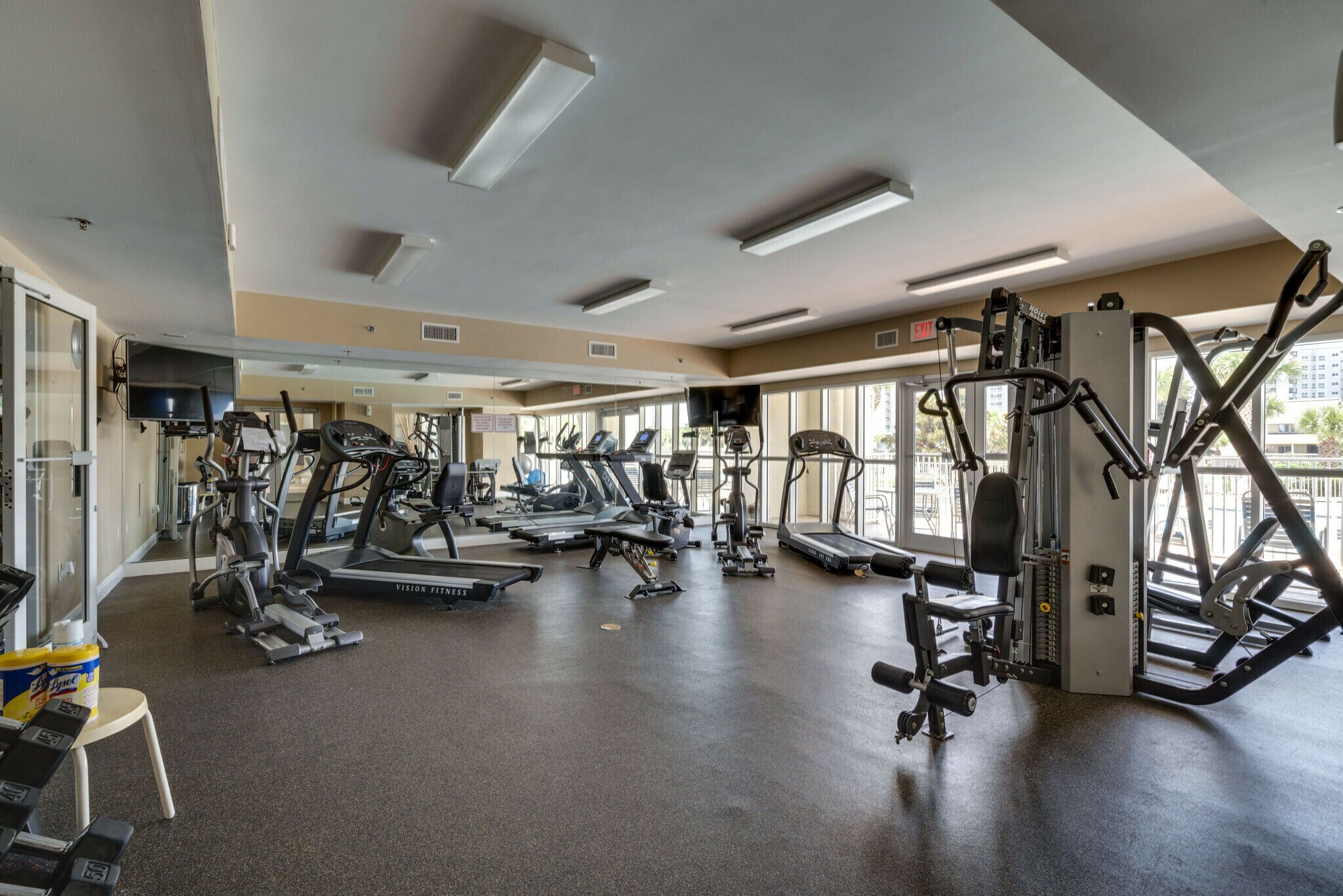 Un gimnasio con cintas de correr, elípticas y equipo de pesas.