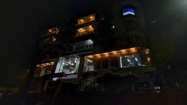 Een meerhoog gebouw met verlichte ramen en balkons in de nacht.
