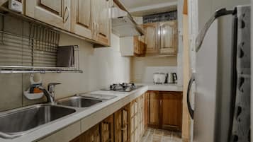 Suite, 2 habitaciones | Área de sala de estar | Televisión de pantalla plana de 32 pulgadas con canales por cable