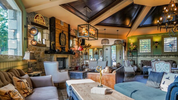 Una sala de estar acogedora y bien decorada con chimenea, asientos cómodos y varios objetos decorativos.