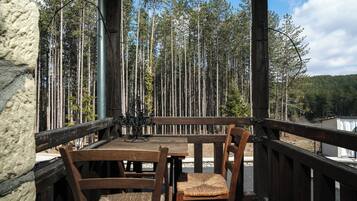 Relax on the deck overlooking the dense forest, surrounded by nature's serenity.