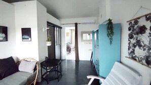 A modern interior with a sofa, a small table, and a hanging plant. - House with land LES MATHES/LA PALMYRE (Les Mathes)