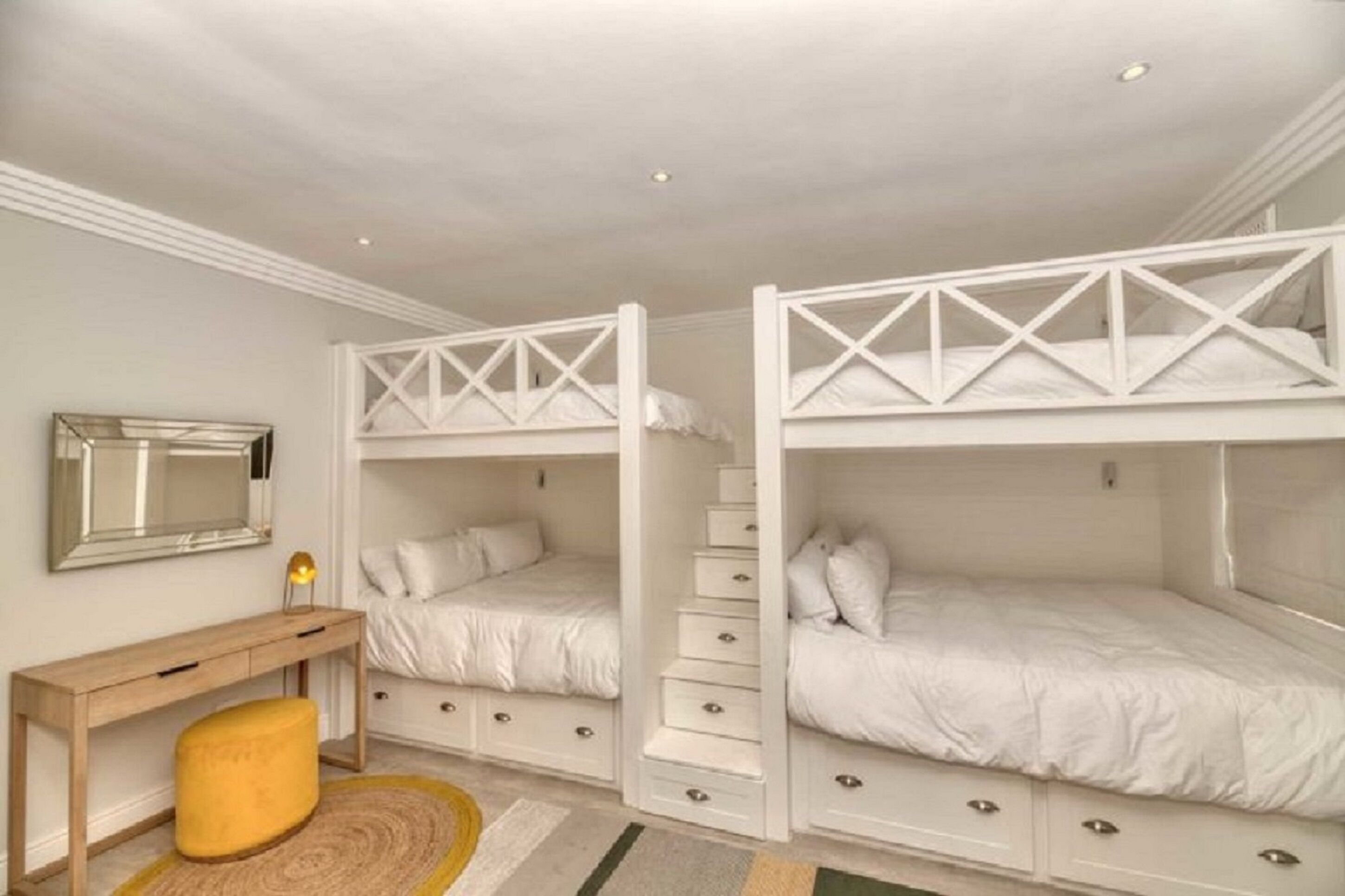 Un dormitorio con literas, un escritorio y una silla.