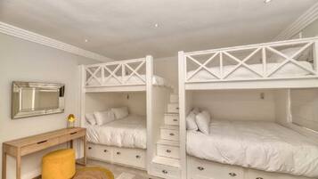 Un dormitorio con literas, un escritorio y una silla.