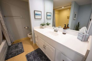 A modern bathroom with a white vanity, a large mirror, and a shower area. - New, Oceanview Remodeled, Private Maisons Sur Mer! (Myrtle Beach)