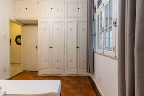 A bedroom with a bed, a wardrobe, and a window with curtains. - 2 Minutes From Copacabana Beach A306 (Rio de Janeiro)