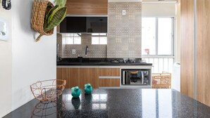 A modern kitchen with a granite countertop, wooden cabinets, and a built-in oven.
