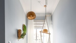 A hallway with a colorful checkered rug, a hanging hammock chair, and a woven wall decoration. - Copacabana Ideal for Couples Rpp913 (Rio de Janeiro)