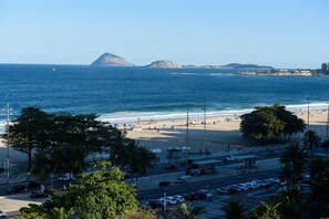 A beach with a parking lot and a road in the foreground.