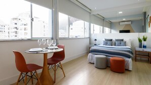 Un dormitorio moderno con una cama grande, una mesita de noche y una ventana con vistas a la ciudad.