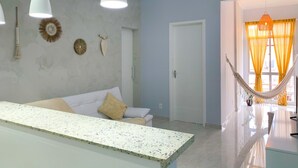 A modern living room with a white sofa, a coffee table, and a hammock by the window. - 6 Minutes From Copacabana Beach Br1033 (Rio de Janeiro)
