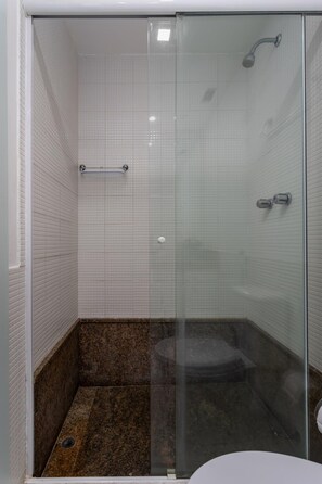 A glass-enclosed shower stall with a marble floor, a towel rack, and a toilet. - Attractive in Barra da Tijuca With a View As1602 (Rio de Janeiro)