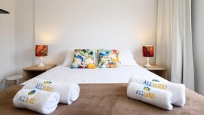Ein Hotelzimmer mit einem Bett, zwei Kissen, zwei Nachttischlampen, einer braunen Decke und zwei Handtüchern mit dem Aufdruck "ALL in RIO".