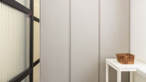 Ein modernes Zimmer mit einer Schiebetür, einem weißen Regal mit einem Korb und einem hellen Boden.