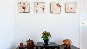 A wooden table with a potted plant, a piggy bank, a vintage coffee grinder, and a briefcase.