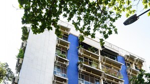 Un edificio de varios pisos con balcones, algunos con plantas.