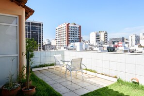 A rooftop terrace with a table and chairs, potted plants, and a cityscape view. - Penthouse in Ipanema Christ View Mqc502 (Rio de Janeiro)