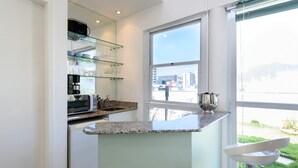 Una cocina moderna con encimera de granito, microondas integrado y cafetera.