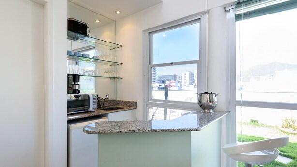A modern kitchen with a granite countertop, a built-in microwave, and a coffee maker.