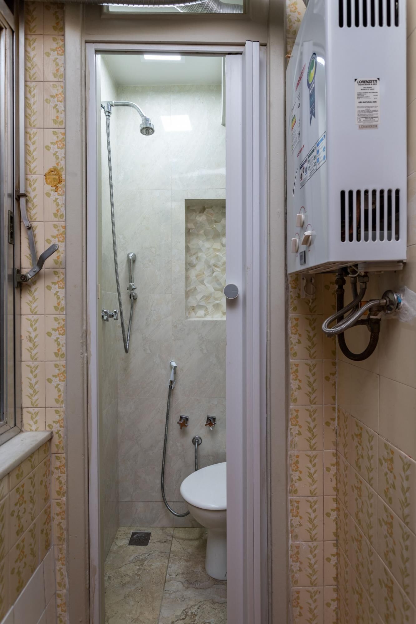 A small bathroom with a shower, toilet, and a water heater.