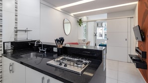 A modern kitchen with a gas stove, stainless steel sink, and white cabinets. - 3 Minutes From Copacabana Beach Df219 (Rio de Janeiro)
