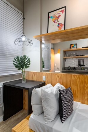 Una cocina americana moderna con encimera de madera, lámpara colgante y un mapa enmarcado en la pared.